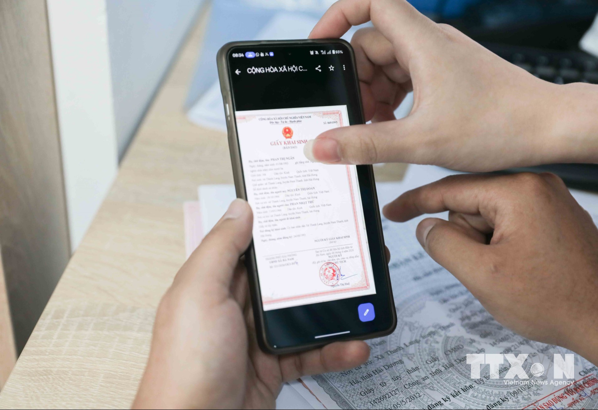 Cán bộ Chi nhánh số 6 Trung tâm Phục vụ hành chính công Hà Nội tại Việt Hưng tận tình hỗ trợ người dân nộp hồ sơ trực tuyến, xóa bỏ rào cản địa giới, giúp tiết kiệm thời gian, chi phí và tạo thuận lợi tối đa cho người dân. (Ảnh: Phan Phương/TTXVN)